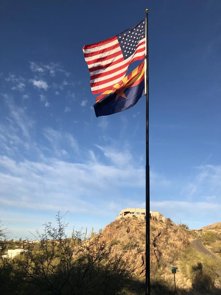 The American flag flying above the Arizona state flag