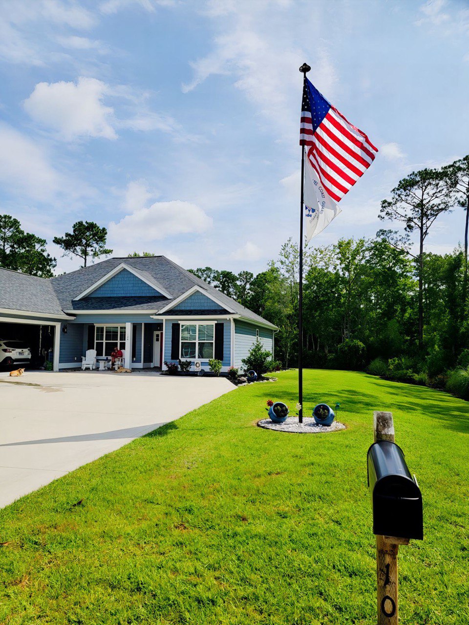 A Phoenix flagpole flying the American flag on a front lawn