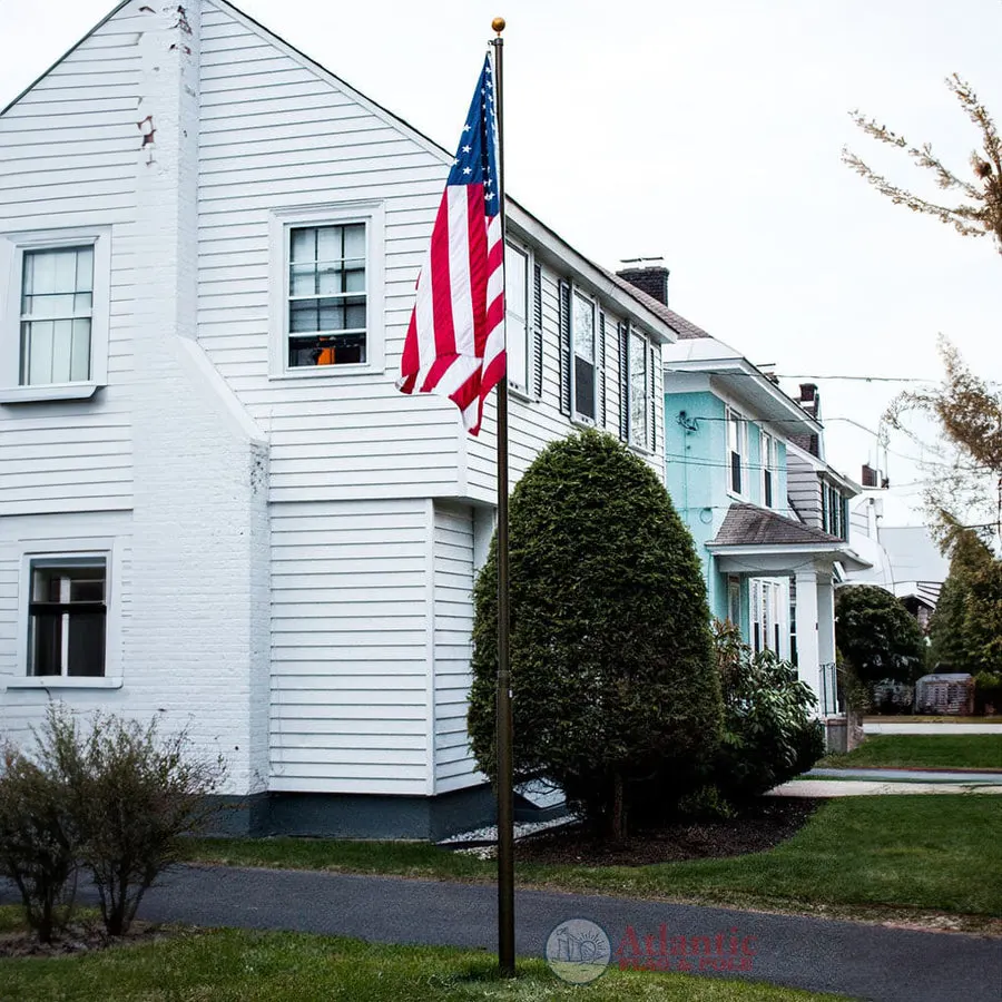 A Phoenix flagpole beside a white two-story colonial